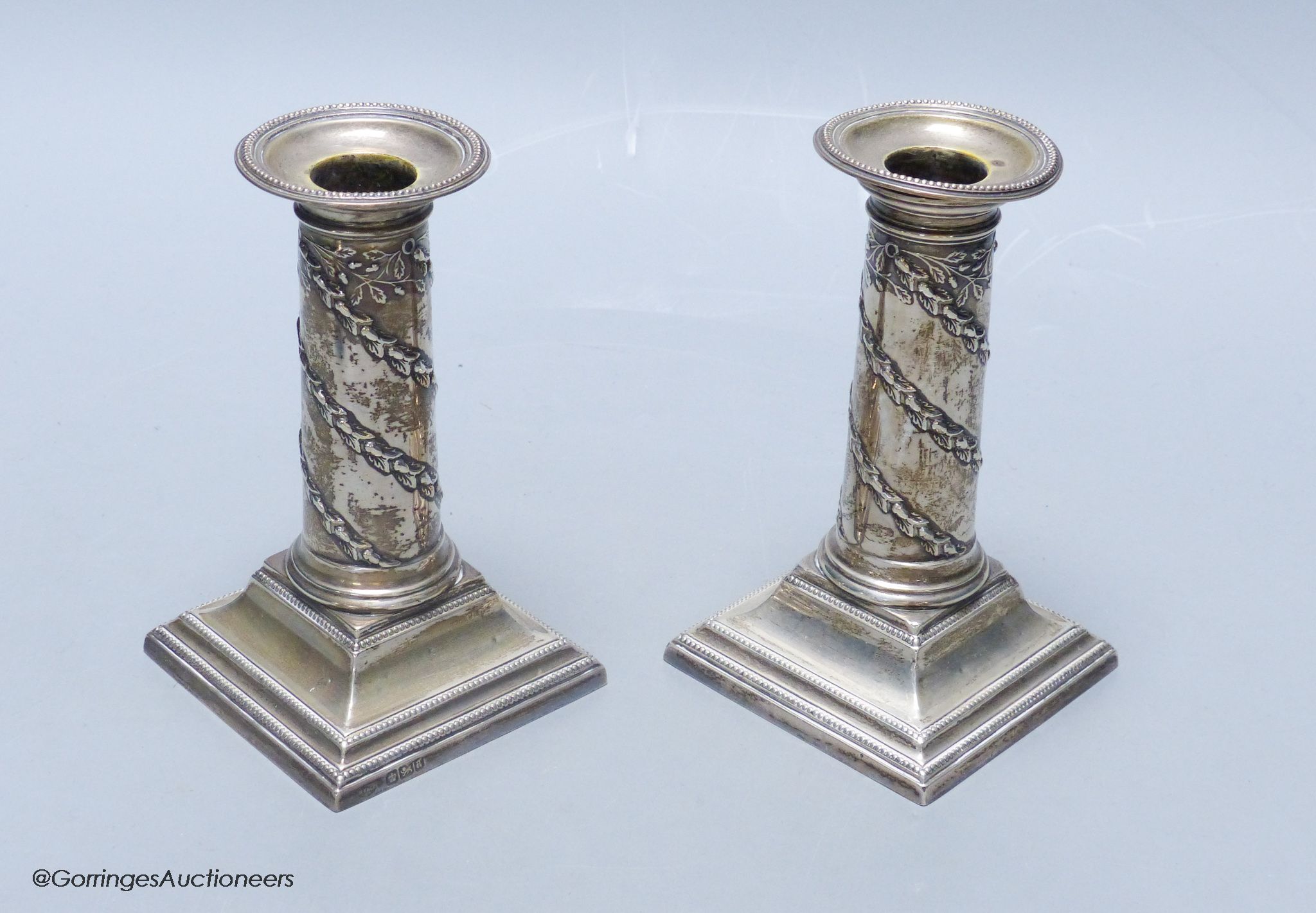 A matched pair of late Victorian silver dwarf candlesticks, Hawksworth, Eyre & Co, Sheffield, 1886 & 1893, approx. 13cm, weighted.